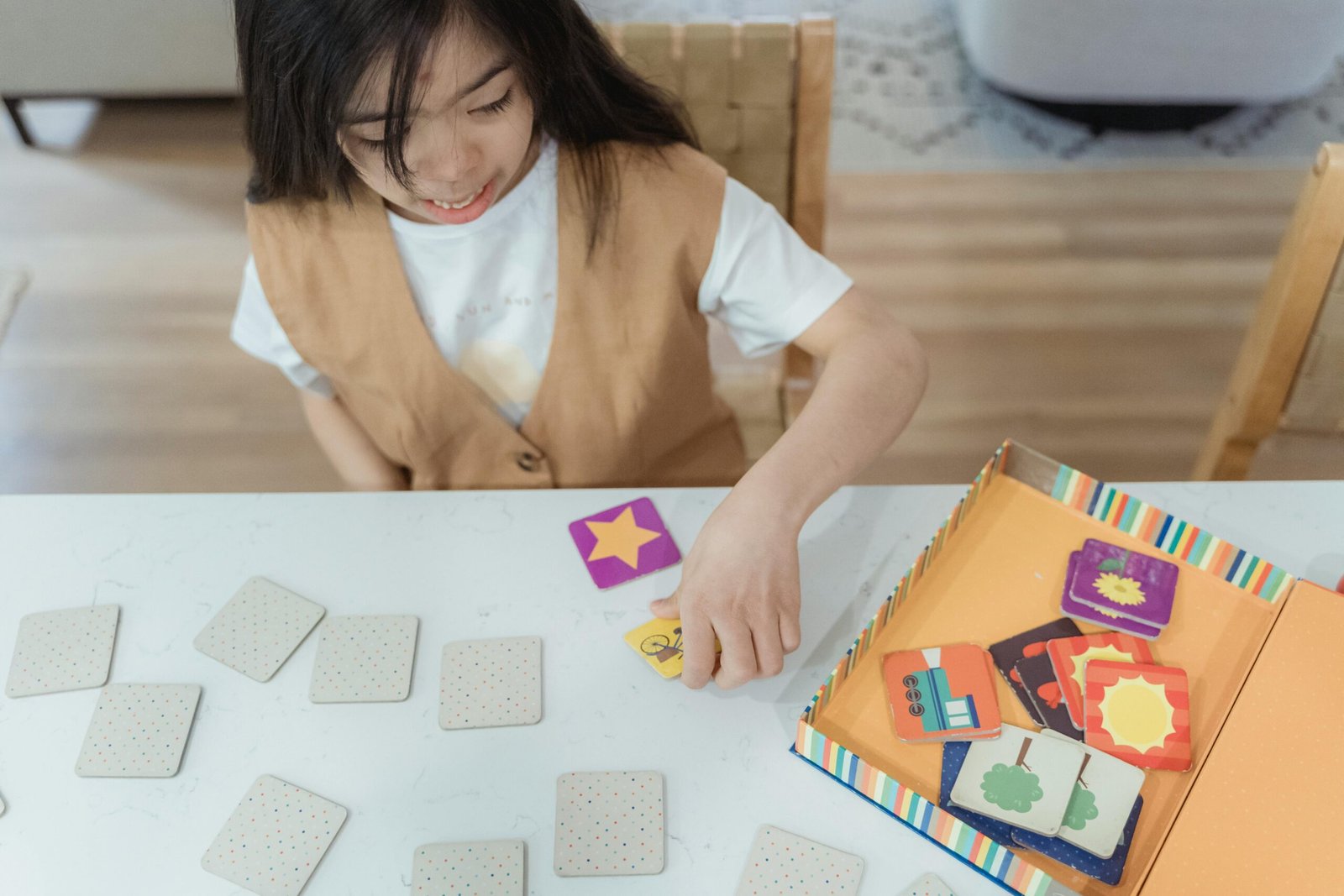 Child enjoys a fun card game indoors, engaging with colorful illustrations.